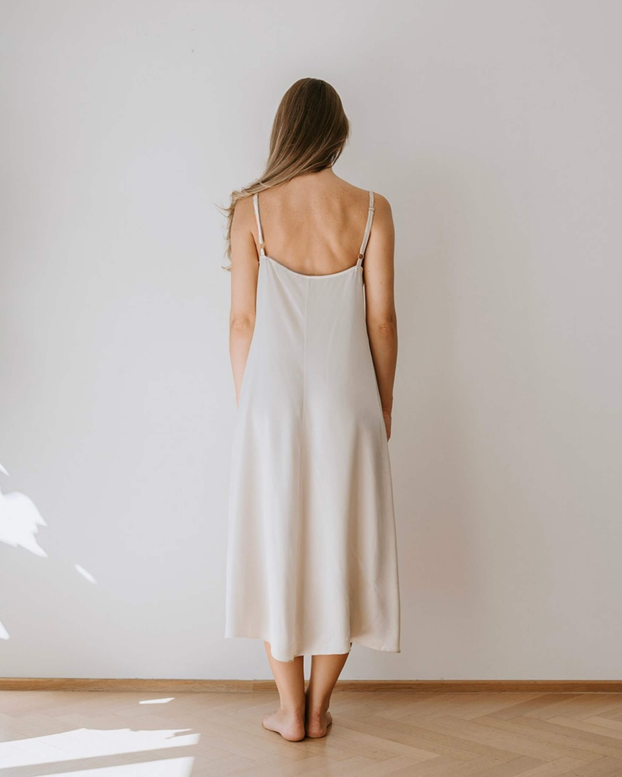 Lang silkenatkjole i champagnefarve med smuk blonde - elegant og minimalistisk